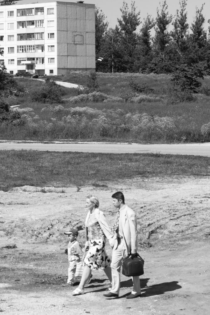 Familie im Sonntagsstaat auf dem Weg zum Bahnhof vor sowjetischem Plattenbau, dressed up family on it's way to the station in front of soviet housing / 23.6.2010, Foto: Robert B. Fishman, ecomedia, C3455