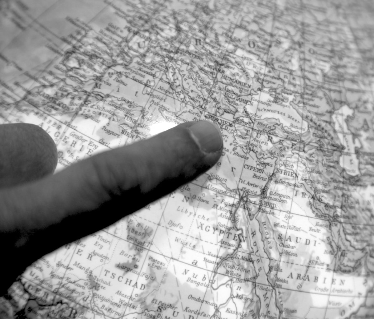 Mit dem Finger auf der Landkarte, Symbolbild Reisen